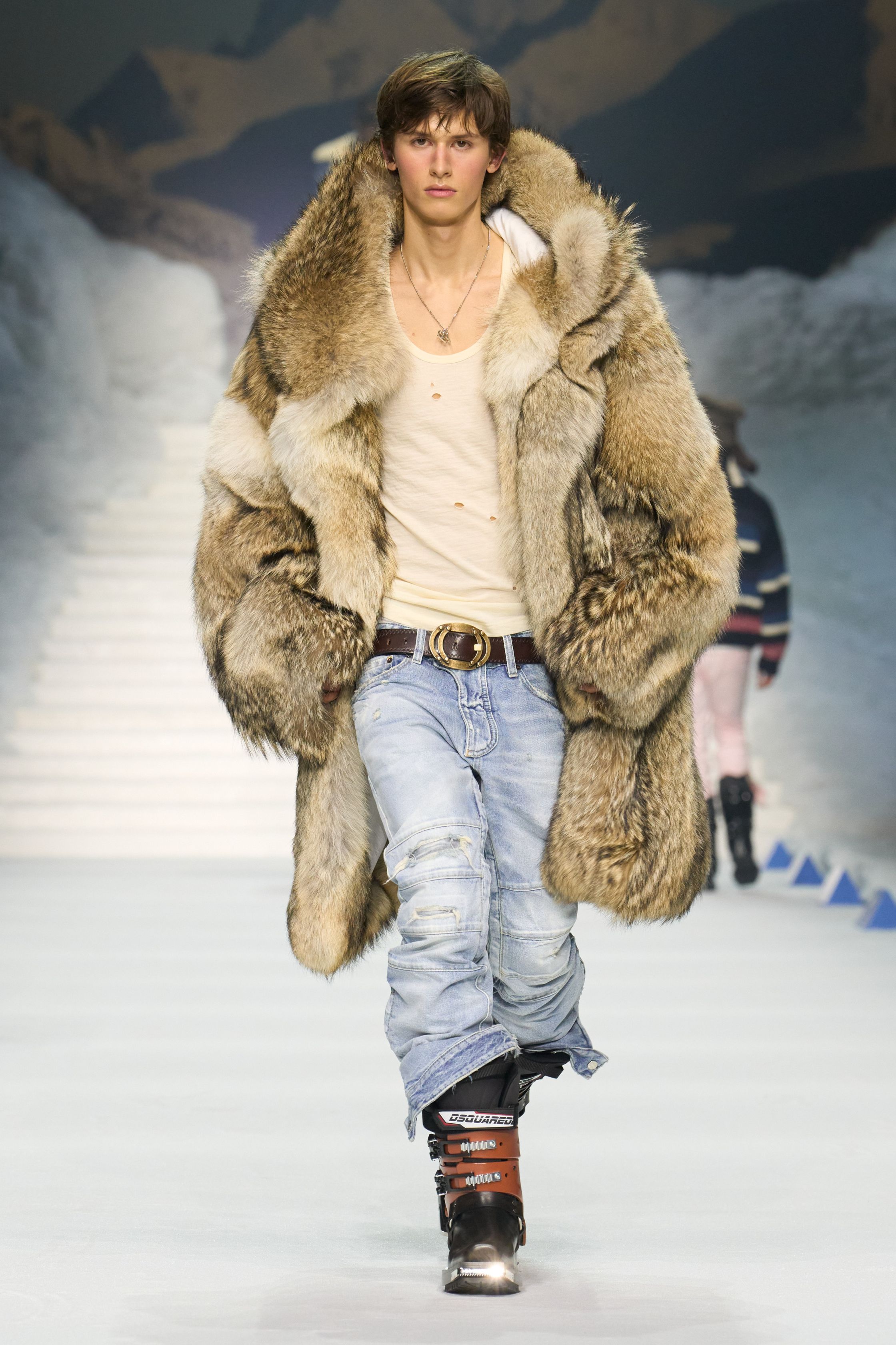 Dsquared2 2026秋冬以夸张的滑雪场景为背景，将加拿大户外精神、Y2K 性感与舞台化时装推至极致。羽绒、毛皮、紧身牛仔与夸张比例不断叠加，身体成为视觉焦点，性感、力量与炫耀被无限放大。这不是现实主义的衣橱，而是一场关于冒险、欲望与表演的时尚狂欢，张扬而直接，忠于品牌一贯的高能量叙事-顽石频道趋势研究